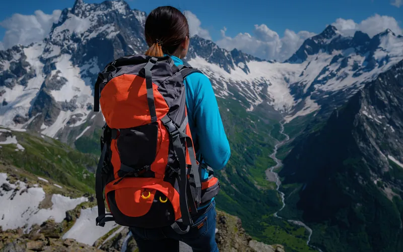 Escursionista con zaino davanti alle montagne